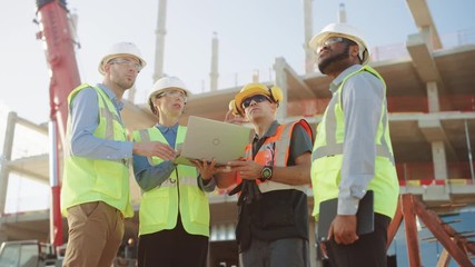 Wall Mural - Diverse Team of Specialists Use Laptop Computer on Construction Site. Real Estate Building Project with Machinery: Civil Engineer, Investor, Businesswoman and Builder Discussing Blueprint Plan