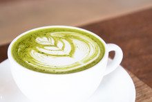 Coffee Cup With Green Matcha Latte Art Foam On Wood Table In Coffee Shop With Copy Space.Coffee Is One Of The Most Popular Beverages.Improve Energy Levels And Burn Fat