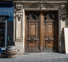 Old Wooden Door. Gorgeous Antique Double Door Entrance Of Baroque Architecture Style Building In Paris France. Vintage Wooden Doorway With Sculptural Relief Details. Old Weathered Wooden Barrel Nearby