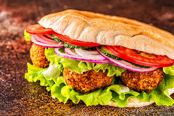 Falafel and fresh vegetables in pita bread.