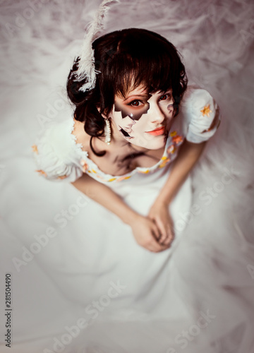 Young Girl With Dark Big Eyes In Image Of Broken Doll From Light