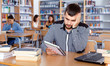 © JackF - Portrait of upset tired male student preparing for exam in university library