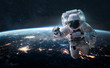 Astronaut in the outer space over the nightly planet Earth. City lights. Abstract wallpaper. Spaceman. Elements of this image furnished by NASA