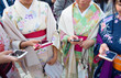 © Mint Images - Women in kimono using smartphones outdoors