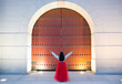 © Mint Images - Rear view of woman standing in front of wooden gate