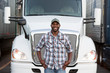 © Mint Images - Portrait of truck driver standing near truck at truck stop