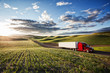 © Mint Images - Commercial truck driving on road passing through field