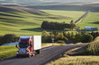 © Mint Images - Commercial truck driving on road passing through field