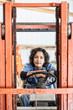 © Mint Images - Portrait of woman sitting in forklift truck