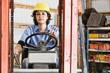 © Mint Images - Worker driving forklift truck in workshop