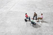 © Mint Images - Architects talking over blueprint while sitting in warehouse