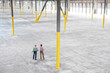 © Mint Images - Rear view of architects checking out interior of empty warehouse