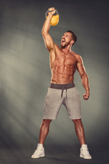 Wall Mural - Strong Muscular Men Exercise With Kettlebell