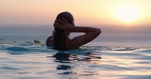 Travel Woman Swimming In Pool At Luxury Hotel Spa With Beautiful Sunset View Of Ocean Mediterranean Travel Holiday Resort Relaxing Lifestyle Freedom 4k