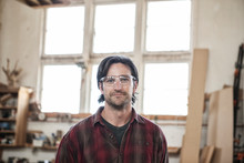 Portrait Of Worker Wearing Safety Glasses In Workshop