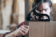 © Mint Images - Carpenter checking square measurements on wooden part in workshop