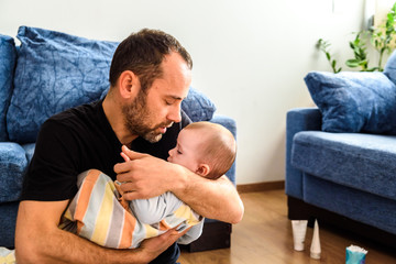 Wall Mural - Dad hugging his baby daughter lovingly.