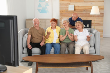 Poster - Happy elderly people watching TV together in living room