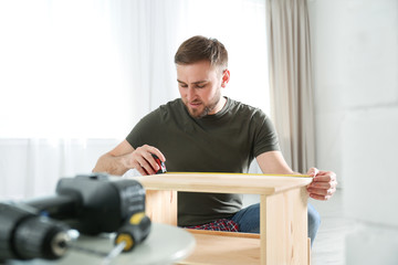 Poster - Young working man using measure tape at home