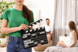 © New Africa - Operator holding clapperboard during the production indoors, closeup