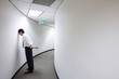 © Mint Images - Frustrated businessman standing in office corridor