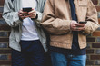 © Mint Images - Midsection of teenage boys using smartphone