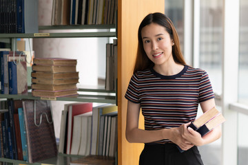 Canvas Print - Student learning in library. Young girl read book in library for doing research assignment.