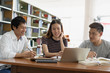 © Pormezz - Group of asian students researching for project in library of university.