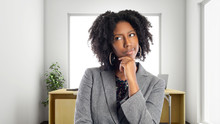 Black African American Businesswoman In An Office Thinking Of Ideas.  She Is An Owner Or An Executive Of The Workplace.  Depicts Careers And Startup Business.