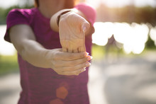 Young Fitness Woman Runner Stretching Hand Before Run In The Park. Outdoor Exercise Activities Concept.