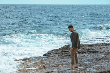 Wall Mural - man walking by rocky beach in windy day summer vacation. enjoy sea view