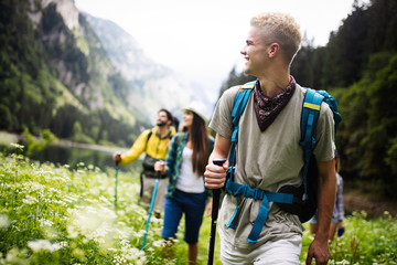 group of friends hikers walking on a mountain at sunset