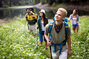 Wall Mural - group of young friends hiking in countryside. multiracial happy people travelling in nature