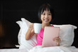 Leinwandbild Motiv Asian Little Chinese Girl playing tablet in bed