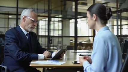 Wall Mural - Aged businessman scrolling company app on tablet unhappy with work results