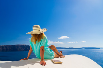 Wall Mural - Luxury travel vacation woman looking at view on Santorini island