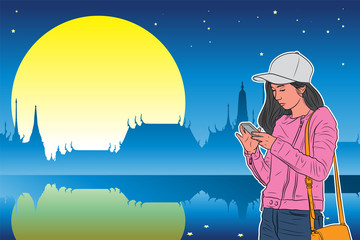 Colorful Asian tourist girl standing and see her smart phone with blue Silhouette temple with stars and full moon