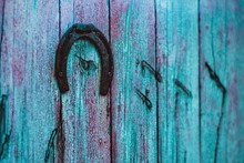 Old Metal Horseshoe Hanging On Blue Wooden Door