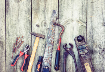 Set of vintage hand construction tools hammers with nails on a wooden background, retro concept .