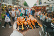 Looking at chicken skewers in hand at the street market in the Netherlands