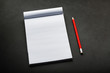 © Alexander - Notepad with a red pencil on a black stone plate background, for education, recording goals and deeds