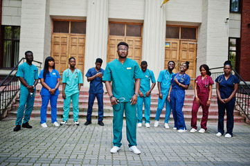 Wall Mural - Group of african medical students posed outdoor against university door.