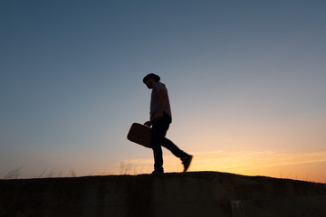 Poster - silhouette of man with suitcase at sunrise