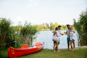 Sticker - Group of friends with cider bottles standing by the boat near the beautiful lake and having fun