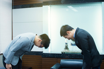 Two business bowing each others for business manner