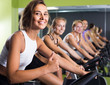 © JackF - Portrait of  women on exercise bike gesturing thumbs up at gym