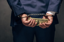 Cropped View Of Handcuffed Man In Suit Holding Bribe On Grey