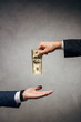 © LIGHTFIELD STUDIOS - cropped view man taking bribe near business partner on grey