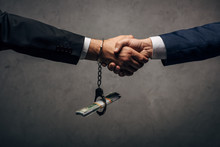 Cropped View Man In Handcuffs Shaking Hands With Business Partner On Grey