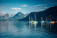 Boats On Calm Blue Mountains Lake. Alps In Background, Swiss Landscape
